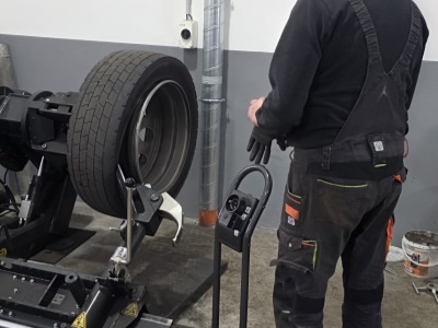 Pracovník obsluhující pneuservisní stroj pro nákladní pneumatiky